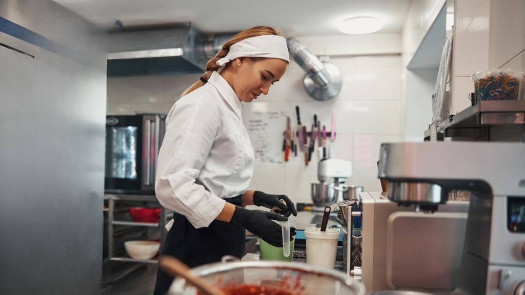 Female chef preparing food in professional kitchen