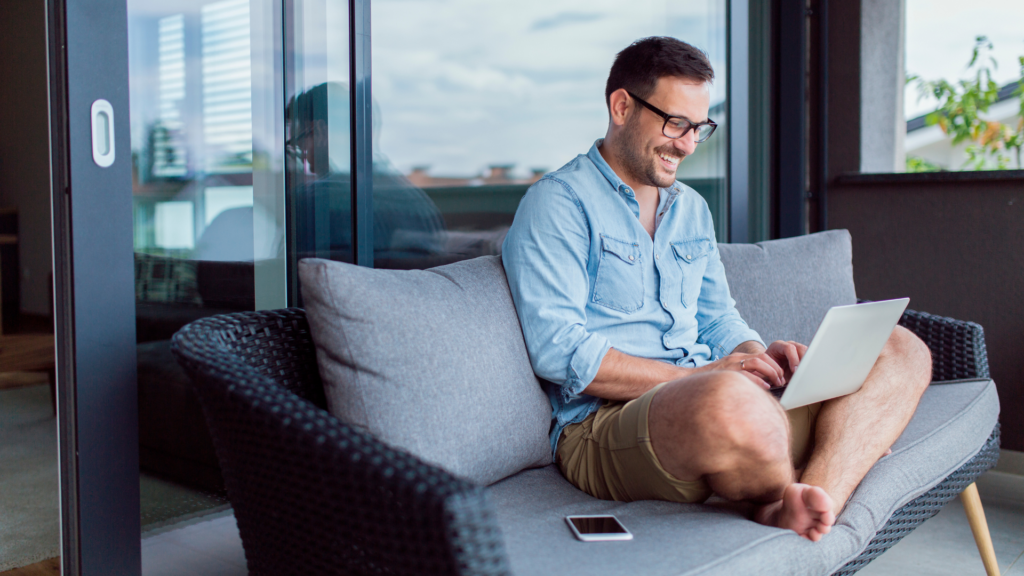 Remote worker working from home on his couch on a laptop