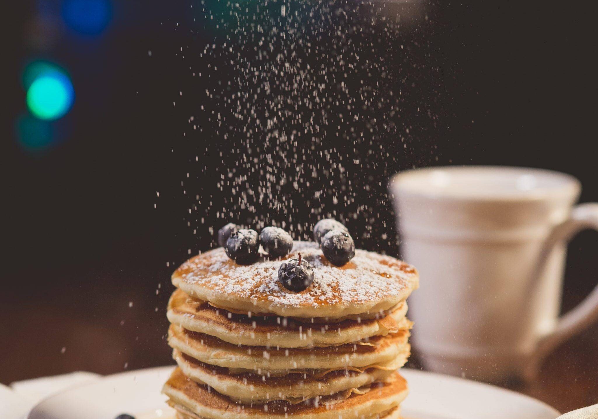 quinoa pancakes topped with blueberries and sprinkled with powdered sugar gecko hospitality